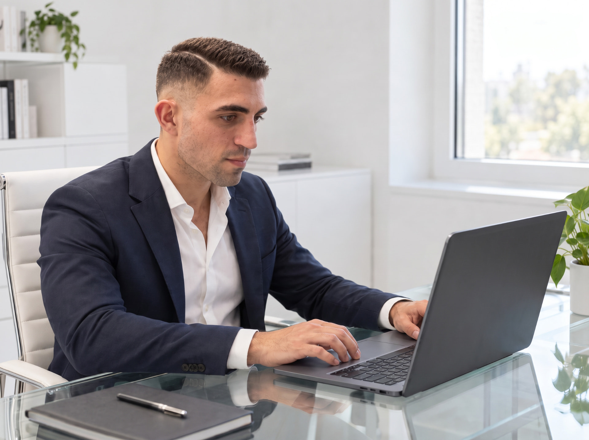 Consulente Immobili Luxury House in giacca blu al lavoro sul laptop in un ufficio luminoso